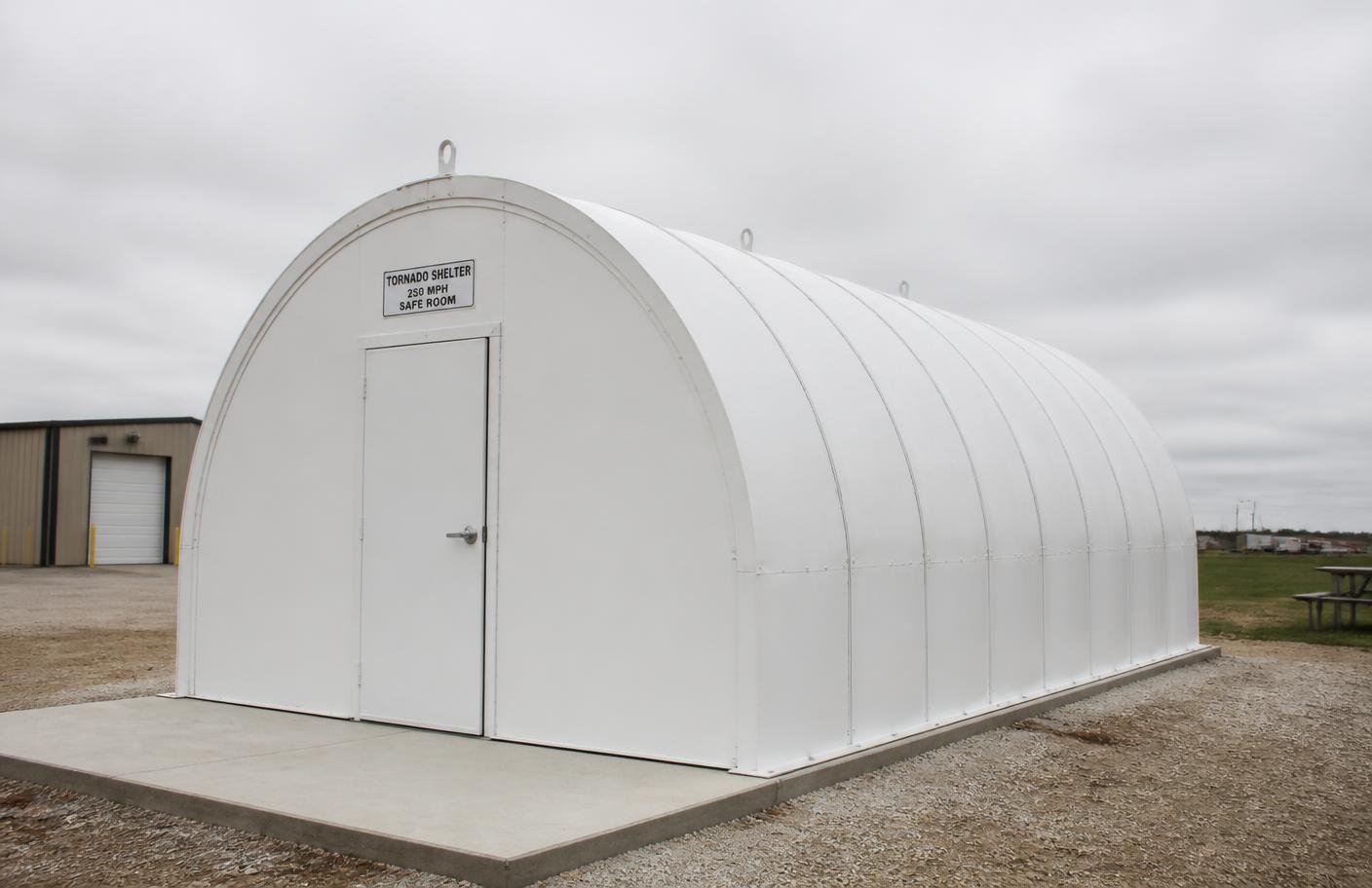 Above-ground quonset-style commercial storm shelter on a concrete pad